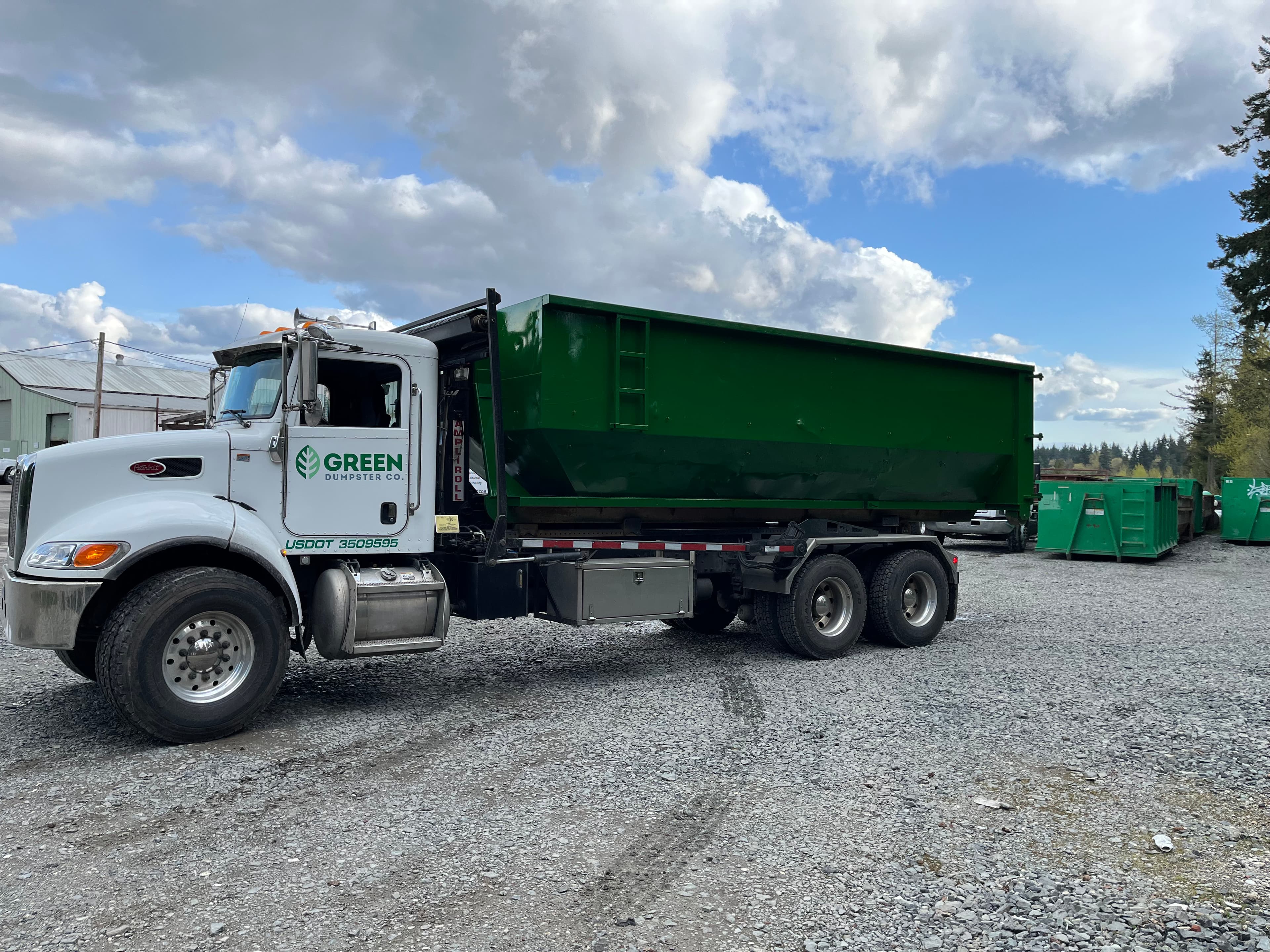 Green Dumpster Co. truck with traditional roll-off dumpster